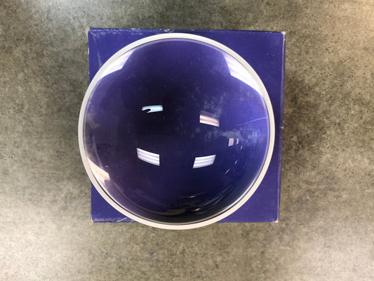 A dome magnifier sitting on the blue box it came in