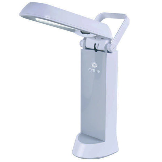 A white lamp that has a handle and the light part flips up and shines light on the darkness