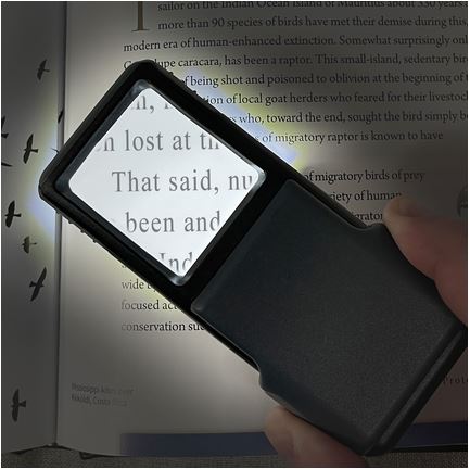 The 5x slide magnifier is a darker color than the 3x. Here is the 5x being used to highlight text from a book in a low lighting setting