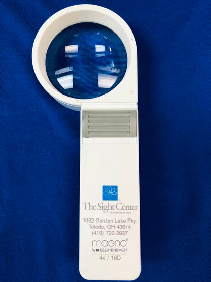 The 4x Magnifier has a circular viewing area. It features a grey on/off button. The Sight Center logo and contact information is printed on the handle along with the brand, Eschenbach, and the strength.