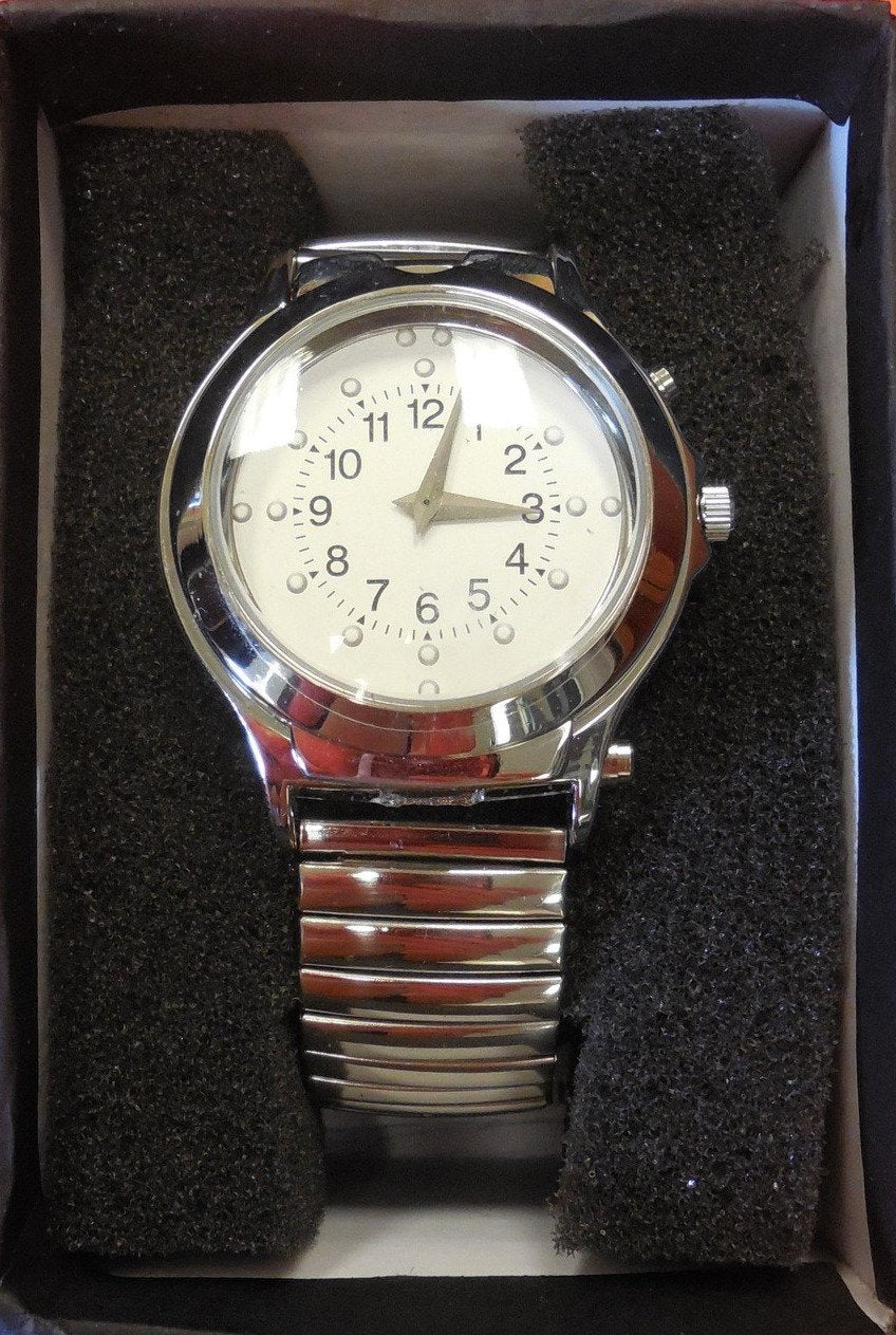 A silver watch with a stretchy band. The face has braille markings to help you tell time. It also has a button that announces the time