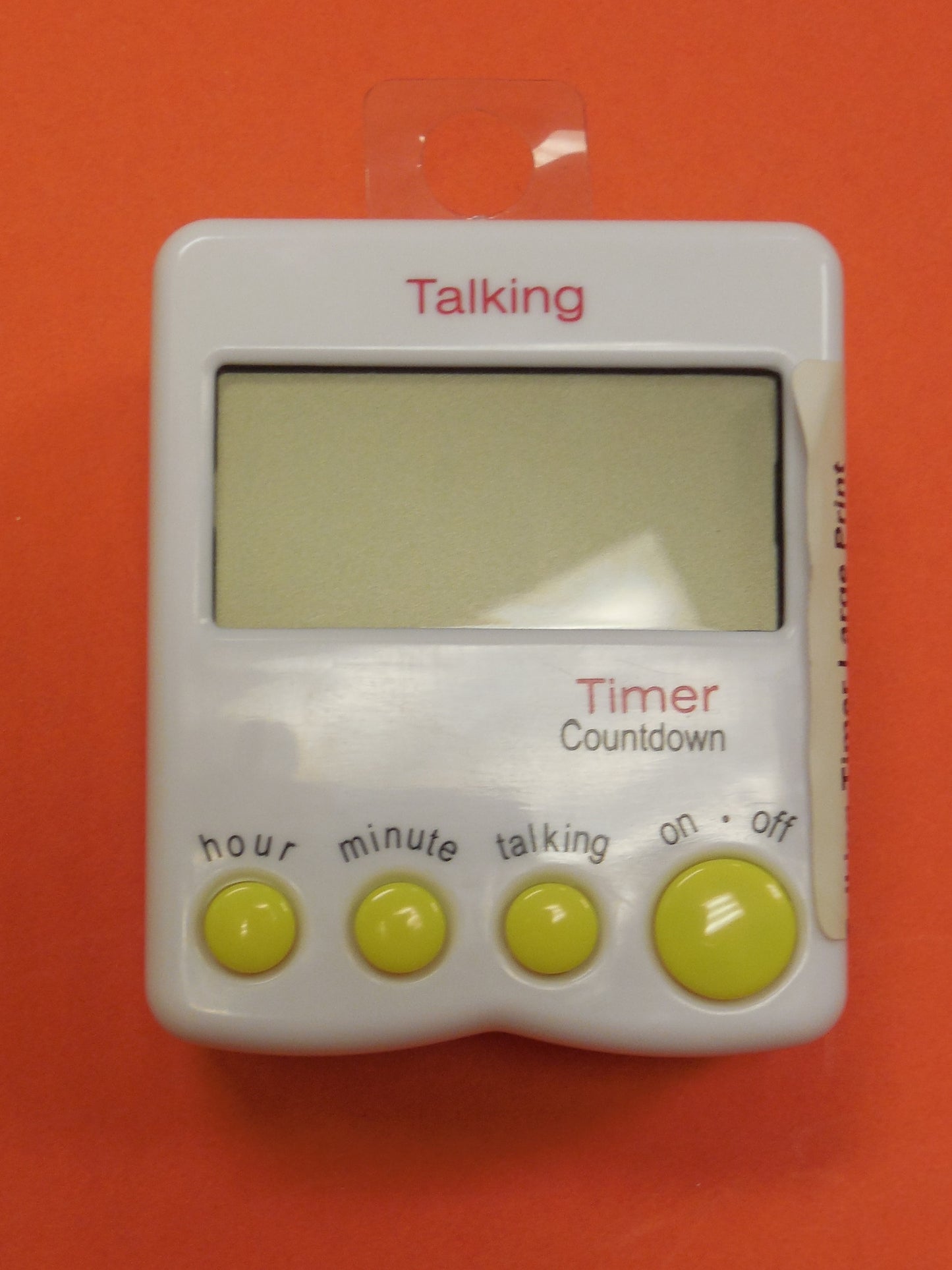A small white device with 4 yellow buttons a large screen to display the time