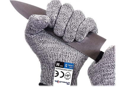 A gloved hand gripping the blade of the knife to show how cut resistant they are