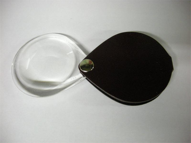 An oval Magnifier attached to a leather sheath for safe keeping