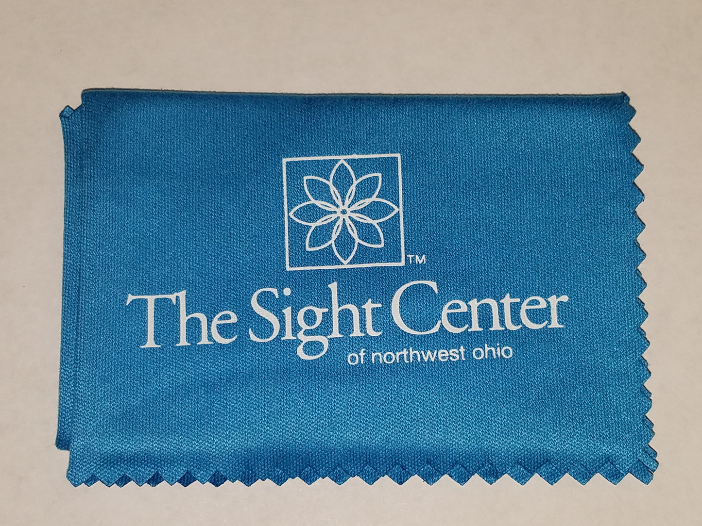 A blue lens cleaning cloth that features the Sight Center of Northest Ohio's logo
