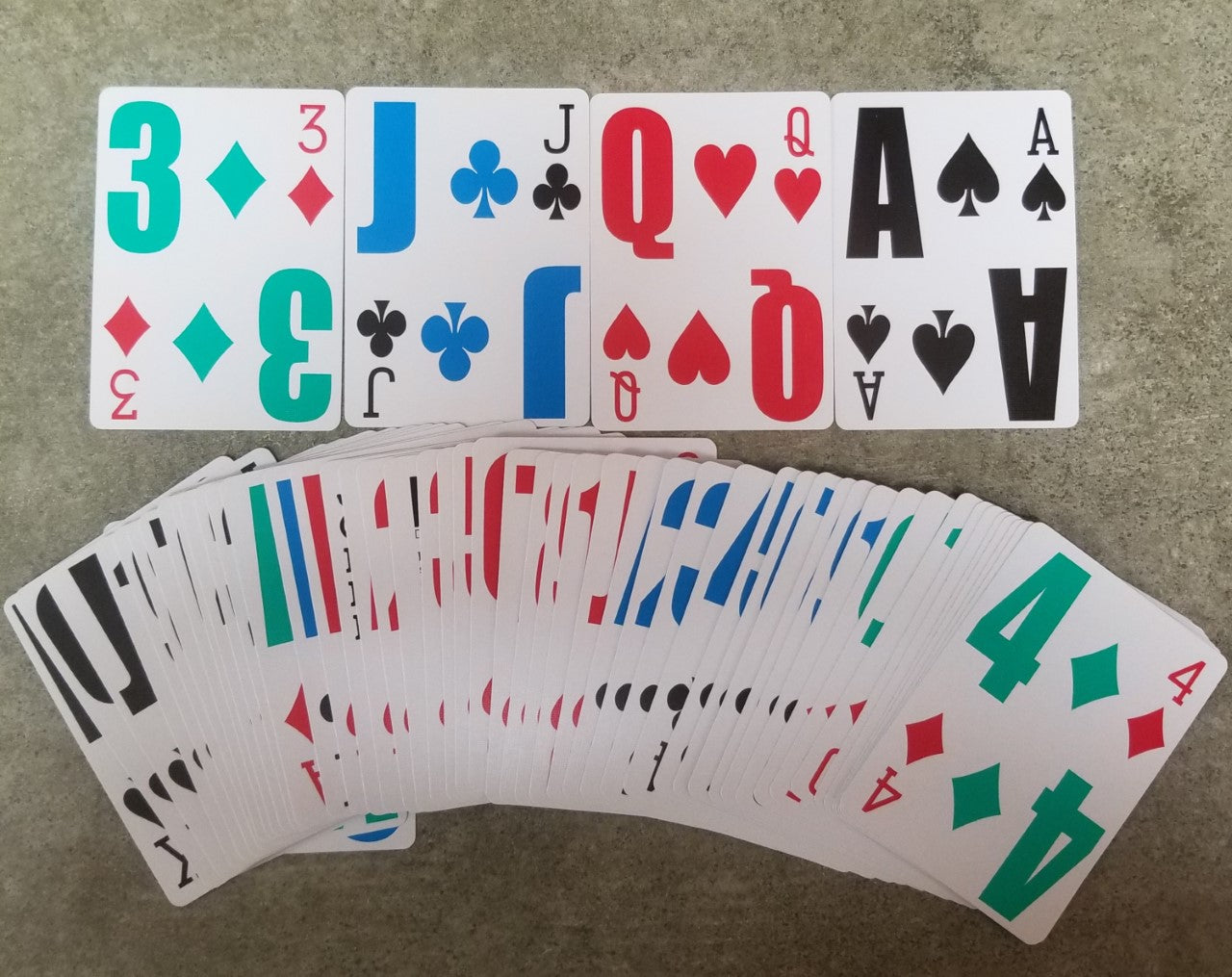 Playing cards with white backgrounds and multi colored large print text