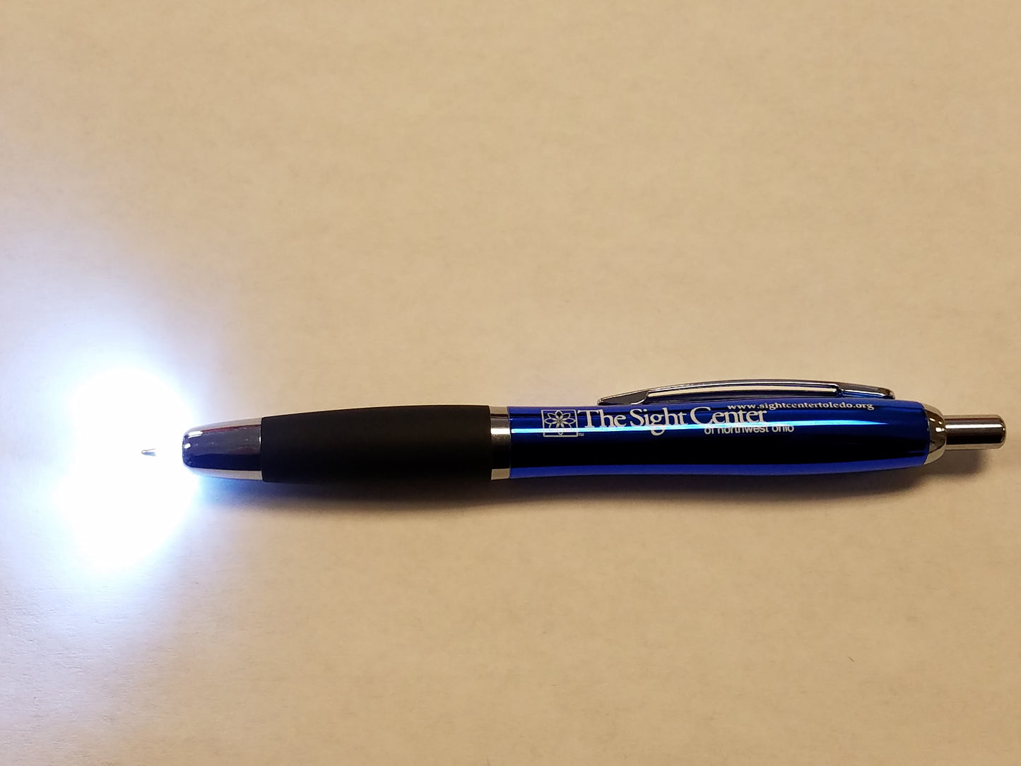 A blue pen with the light on the tip on