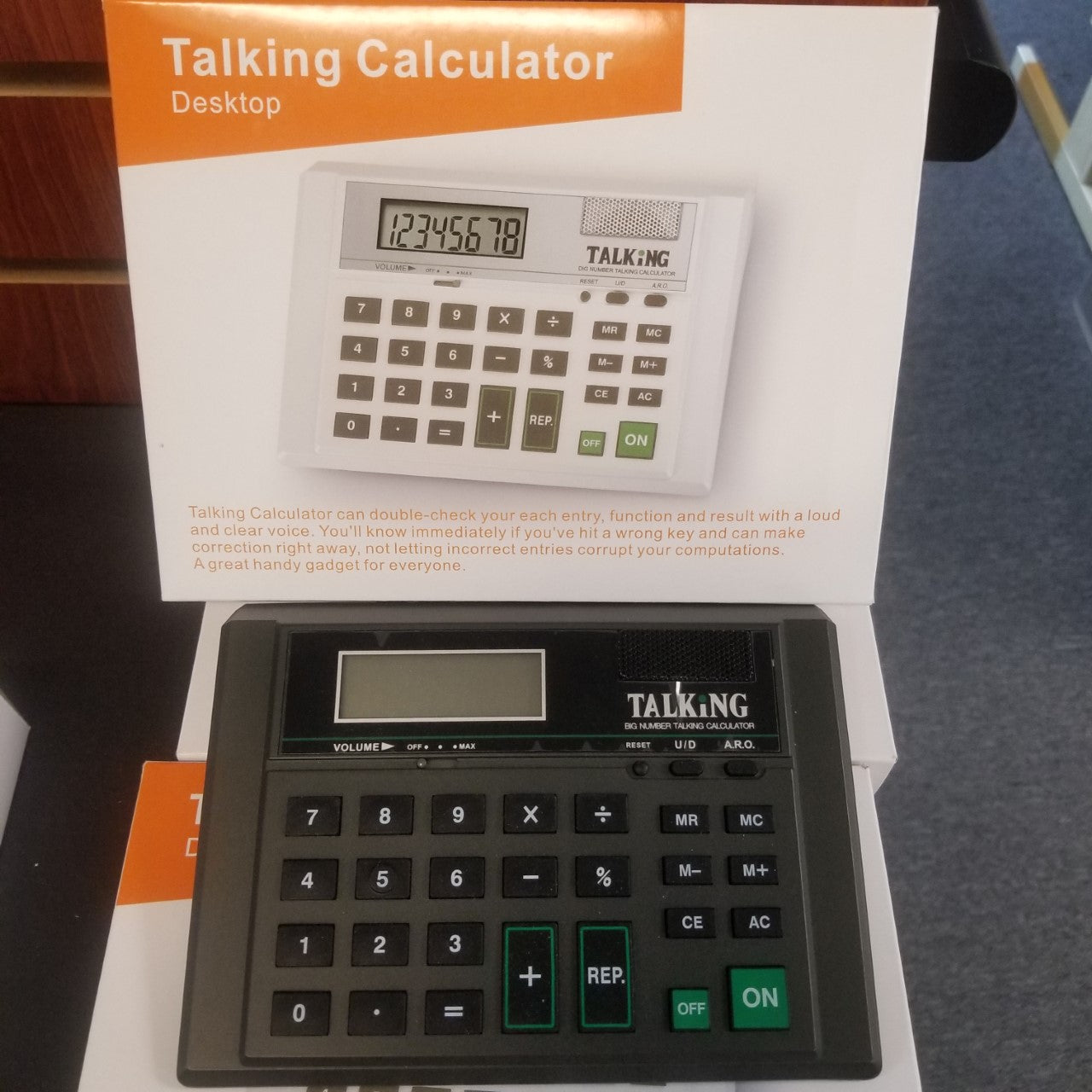 Black, gray and green calculator next to box for talking calculator